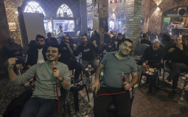 Des Arabes israéliens célébrant le premier but du Maroc lors du match de la Coupe du monde de football Qatar 2022 entre le Maroc et le Portugal, dans un café à Jaffa, le 10 décembre 2022. (Crédit : Ahmad Gharabli/AFP)
