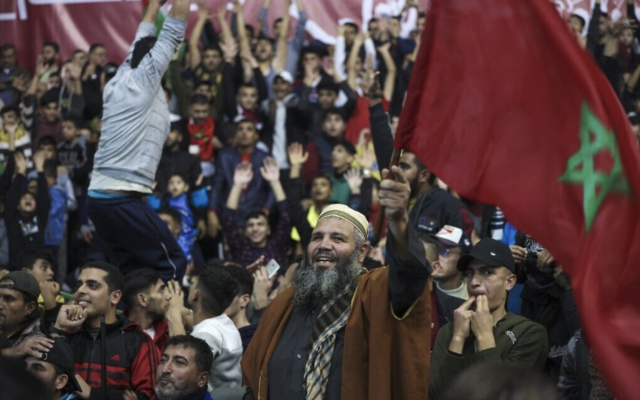 Des supporters palestiniens soulevant des drapeaux marocains et applaudissant en regardant le match de la Coupe du monde Qatar 2022 entre le Portugal et le Maroc dans la ville de Gaza, le 10 décembre 2022. (Crédit : Mohammed Abed/AFP)