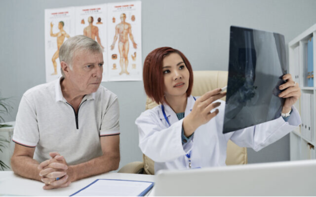 Illustration : Un médecin montrant une radiographie d'une fracture à un patient. (Crédit : DragonImages via iStock by Getty Images)
