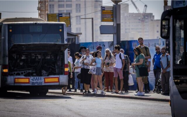 Des passagers attendant un bus à l'entrée de Jérusalem, le 1er août 2022. (Crédit : Olivier Fitoussi/Flash90)