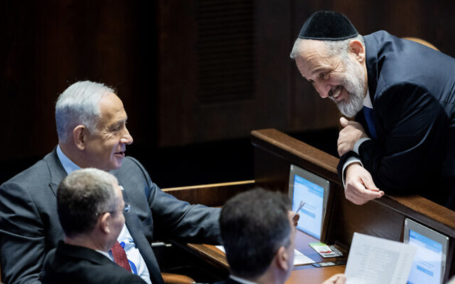 Le leader du Shas, Aryeh Deri, à droite, s'entretenant avec le chef du Likud, Benjamin Netanyahu, en haut à gauche, et le député du Likud, Yariv Levin, en bas à gauche, lors de l'élection de ce dernier au poste de président de la Knesset, le 13 décembre 2022. (Crédit : Yonatan Sindel/Flash90)