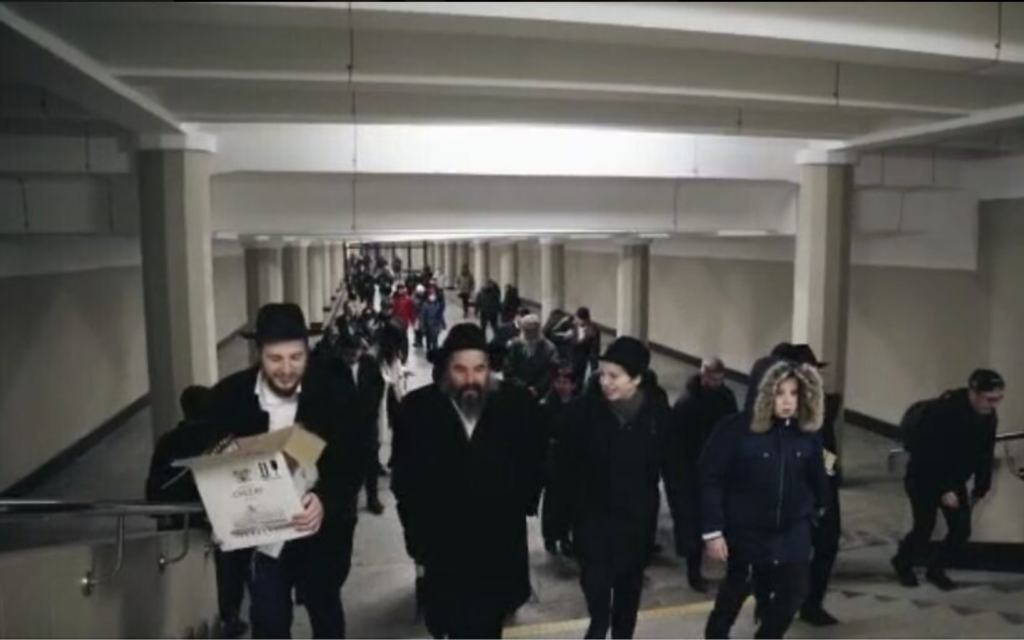  Le rabbin Moshe Moskowitz, deuxième à partir de la gauche, et ses enfants traversant une station de métro, le premier soir de Hanoukka, à Kharkiv, en Ukraine, le 18 décembre 2022. (Crédit : Kharkiv Choral Synagogue) 
