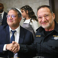 Le chef d’Otzma Yehudit Itamar Ben Gvir (à gauche) et le chef de la police Kobi Shabtai lors de la Bat Mitzah de la fille de Ben Gvir, dans l'implantation de Kiryat Arba en Cisjordanie, le 8 décembre 2022. (Crédit : Arie Leib Abrams/Flash90)