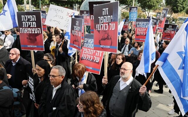 Des avocats se rassemblent lors d'une manifestation contre les plans controversés du gouvernement israélien visant à remanier le système judiciaire, devant la Cour de justice du district de Tel Aviv, le 12 janvier 2023. (Crédit : JACK GUEZ / AFP)