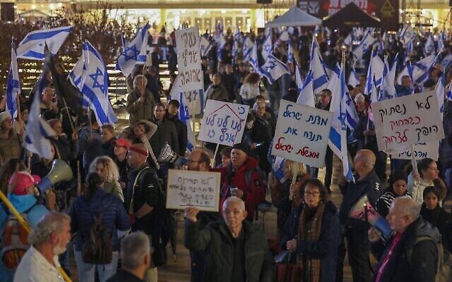 Des manifestants israéliens brandissent des pancartes lors d'un rassemblement contre le nouveau gouvernement d'extrême droite du Premier ministre Benjamin Netanyahu dans la ville côtière de Tel Aviv le 14 janvier 2023. (Crédit : AHMAD GHARABLI / AFP)