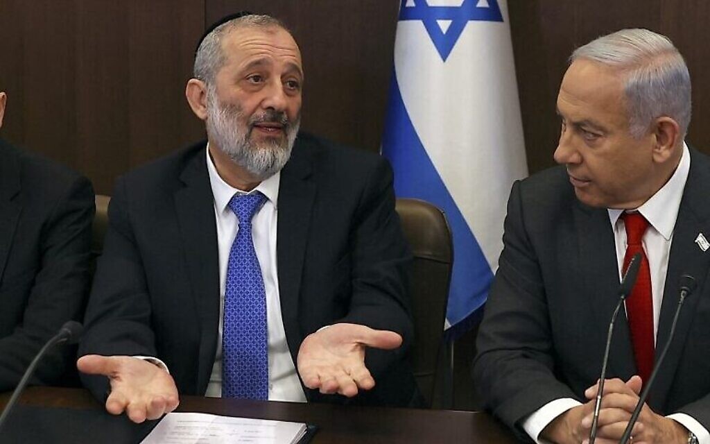 Le ministre de l'Intérieur et de la Santé Aryeh Deri, au centre, entre le Premier ministre Benjamin Netanyahu, à droite, et le ministre de la Justice Yariv Levin, à gauche, lors d'une réunion du cabinet au bureau du Premier ministre de Jérusalem, le 8 janvier 2023. (Crédit : RONEN ZVULUN / POOL / AFP)
