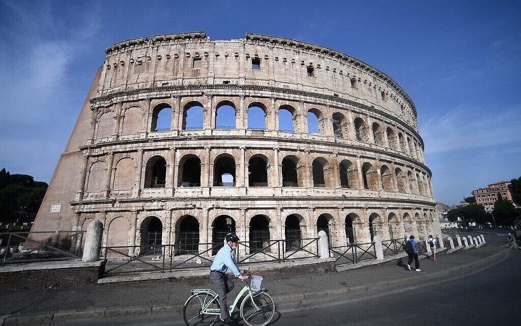 Un cycliste roule le long du Colisée, à Rome, le 25 juin 2021. (Crédit : Filippo Monteforte/AFP)