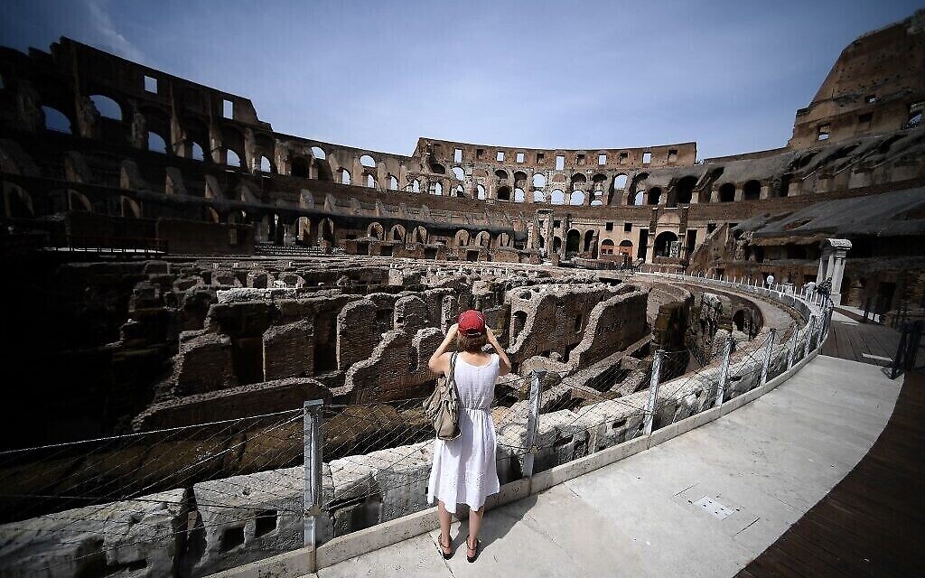 Une touriste prend une photo à l’intérieur du Colisée, à Rome, le 25 juin 2021. (Crédit : Filippo Monteforte/AFP)