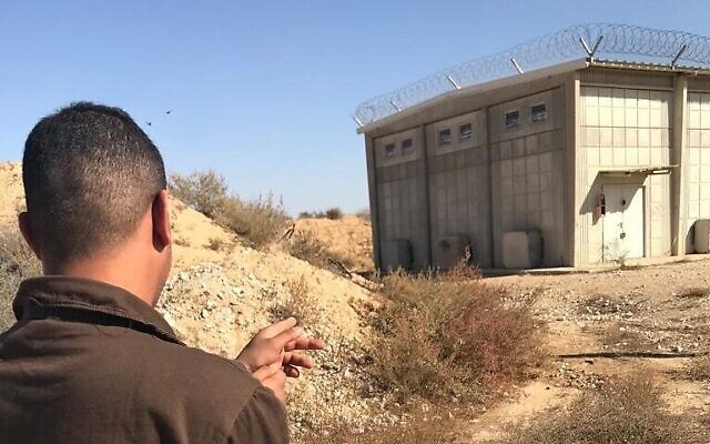 Un détenu bédouin montre du doigt un bunker de stockage de Tsahal sur la base de Sde Teiman, dans le sud d'Israël, après qu'il y soit entré par effraction avec plusieurs autres personnes pour y voler 30 000 balles, lors d'une reconstitution de crime, sur une image publiée par la police le 20 décembre 2022. (Crédit : Police israélienne)