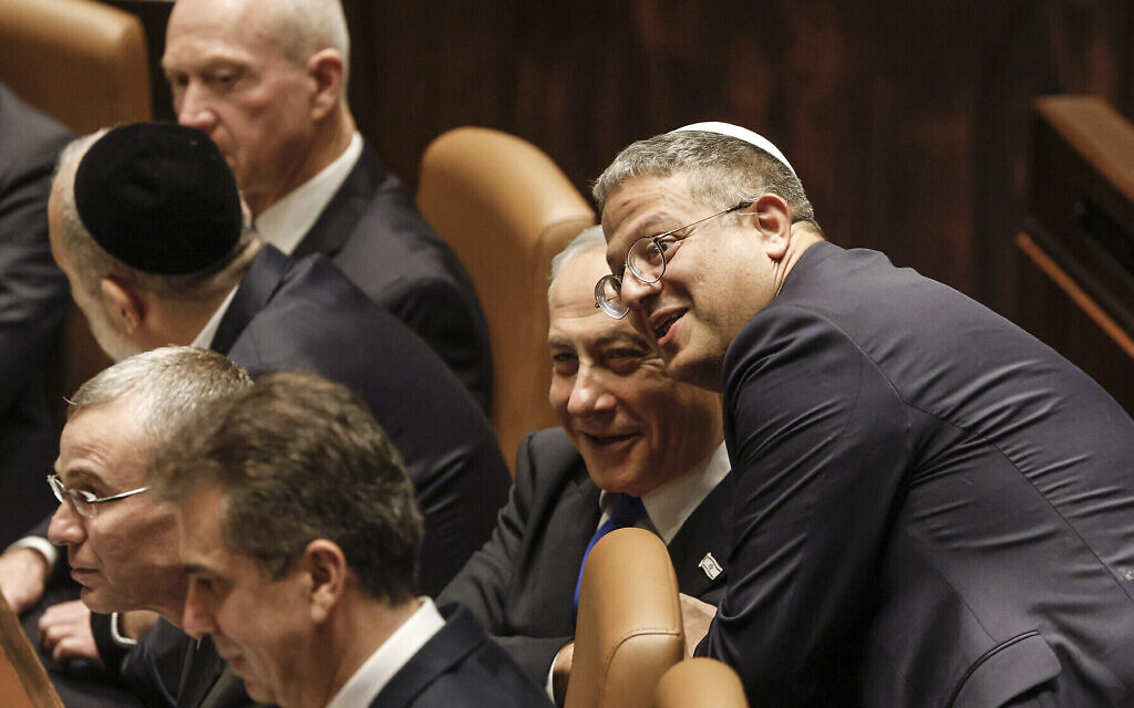 Le nouveau ministre de la Sécurité nationale Itamar Ben-Gvir, à droite, s'entretenant avec le Premier ministre israélien Benjamin Netanyahu lors de l'investiture du nouveau gouvernement de droite à la Knesset, le Parlement d'Israël, le 29 décembre 2023. (Crédit : Amir Cohen/Pool Photo via AP)