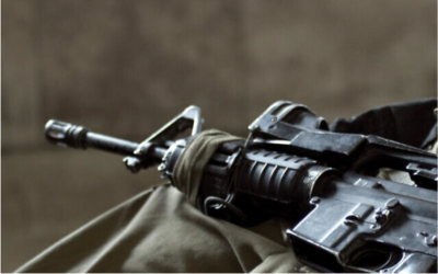 Illustration : Un fusil d'assaut sur les genoux d'un soldat israélien (Crédit : Vanish_Point/iStock by Getty Images)