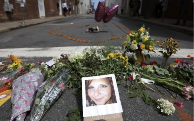 Des fleurs entourant une photo de Heather Heyer, 32 ans, tuée lorsqu'une voiture a foncé sur une foule de personnes qui protestaient contre le rassemblement suprémaciste blanc Unite the Right, à Charlottesville, en Virginie, le 13 août 2017. (Crédit : Chip Somodevilla/Getty Images/AFP)