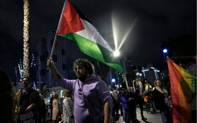 Un manifestant tenant un drapeau palestinien lors d'une manifestation contre le nouveau gouvernement du Premier ministre Benjamin Netanyahu, à Tel Aviv, le 7 janvier 2023. (Crédit : AP Photo/ Tsafrir Abayov)
