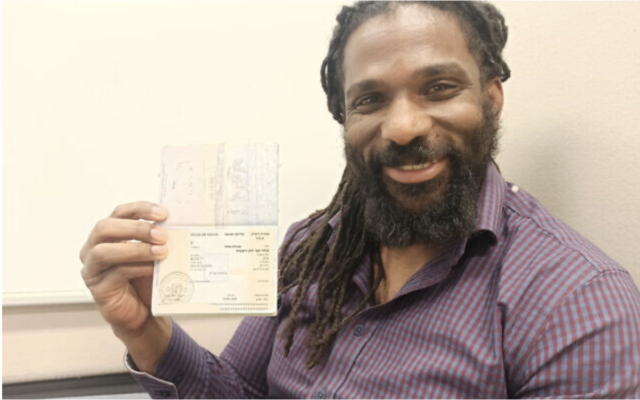 David Ben Moshe tenant son visa d'immigrant nouvellement reçu, dans l'un des bureaux de l'Autorité de la Population et de l’Immigration, le 12 janvier 2023. (Crédit : David Ben Moshe)