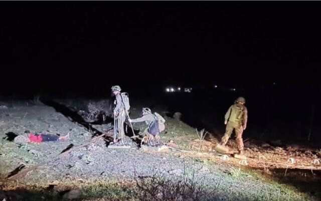 Des soldats israéliens du génie de combat extrayant un jeune homme d'un champ de mines, près du kibboutz Meitzar, le 24 janvier 2023. (Crédit : Armée israélienne)