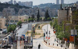 Personnes marchant dans une rue principale de Neve Yaakov, Jérusalem, le 12 avril 2020. (Crédit : Nati Shohat/Flash90)
