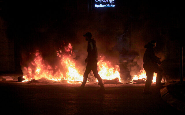Des Palestiniens brûlent des pneus et bloquent les rues menant au Tombeau de Joseph, dans la ville de Naplouse en Cisjordanie, le 17 janvier 2023. (Crédit : Nasser Ishtayeh/Flash90)