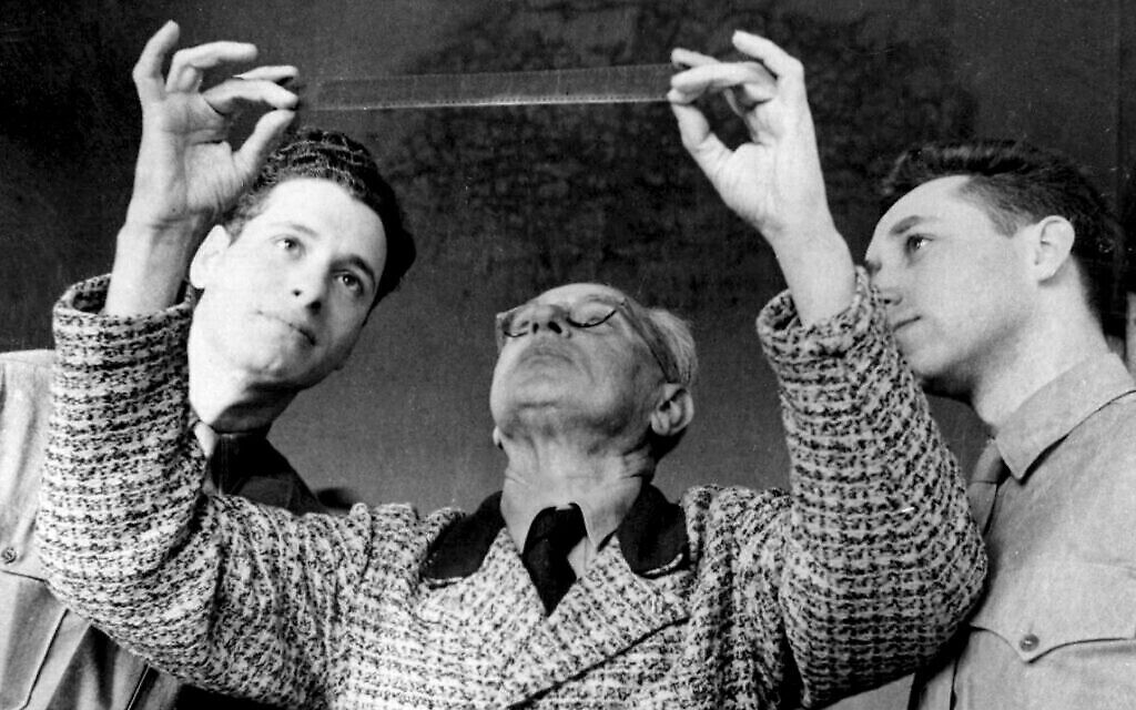 Le photographe d’Hitler, Heinrich Hoffmann (au centre), a aidé Stuart Schulberg (à droite) et d’autres membres de l’OSS Field Film Photographic Branch - War Crimes Unit à examiner les images après sa capture par les forces alliées. (Avec la permission de Kino Lorber)
