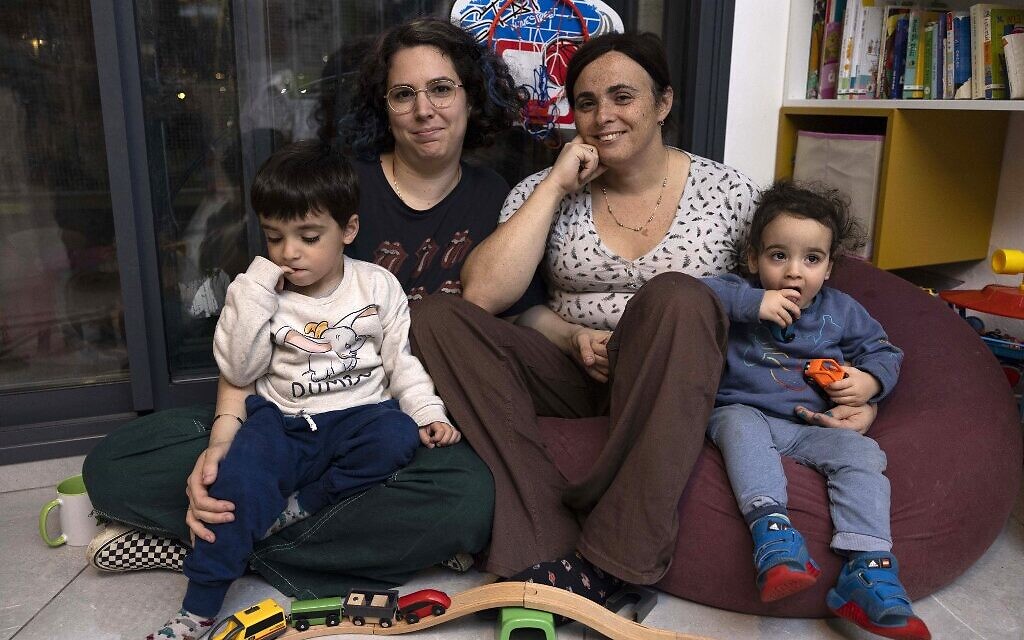 Yael Rashlin (droite), une femme transgenre, pose pour une photo avec sa partenaire Hadar et leurs enfants Yarden et Hillel, à leur domicile dans la ville de Tzur Hadassah, dans le centre d'Israël, le 1er décembre 2022. (Crédit : MENAHEM KAHANA / AFP)