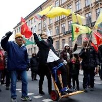 Des manifestants brandissent des drapeaux ornés de portraits d’Abdullah Ocalan, chef du Parti des travailleurs du Kurdistan (PKK), et défilent avec une effigie du président turc Recep Tayyip Erdogan, lors d’une manifestation organisée par le Conseil Démocratique Kurde contre la candidature d’Erdogan et de la Suède à l’OTAN, à Stockholm le 21 janvier 2023. (Crédit : Christine OLSSON/TT News Agency/AFP)