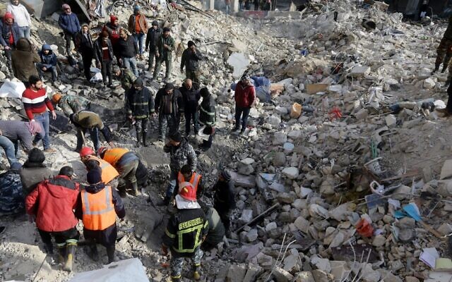 Des équipes de secours syriennes recherchent des victimes et des survivants coincés sous les décombres d'immeubles effondrés à Alep, le 7 février 2023, à la suite d'un séisme meurtrier qui a frappé la région la veille. (Crédit : LOUAI BESHARA / AFP)