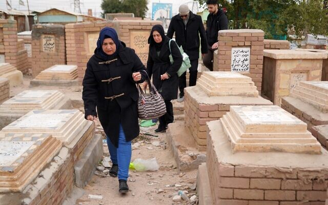 Des gens visitent des tombes au cimetière de Wadi-al-Salam dans la ville sainte de Najaf, en Irak, le 10 février 2023. Le cimetière de Wadi-al-Salam, souvent décrit comme le plus grand du monde, témoigne silencieusement de la vie et de la mort sur 14 siècles. (Crédit : Qassem al-KAABI / AFP