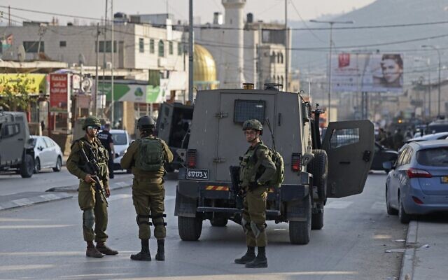 Les forces de sécurité israéliennes déployées après la mort de deux Israéliens dans une fusillade, à Huwara, le 26 février 2023. (Crédit : Ahmad Gharabli/AFP)