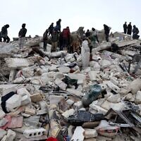 Des habitants et des sauveteurs recherchent des victimes et des survivants dans les décombres de bâtiments effondrés à la suite d'un tremblement de terre dans le village de Besnaya, dans la province d'Idlib, au nord-ouest de la Syrie, tenue par les rebelles, à la frontière avec la Turquie, le 6 février 2022. (Crédit : OMAR HAJ KADOUR / AFP)