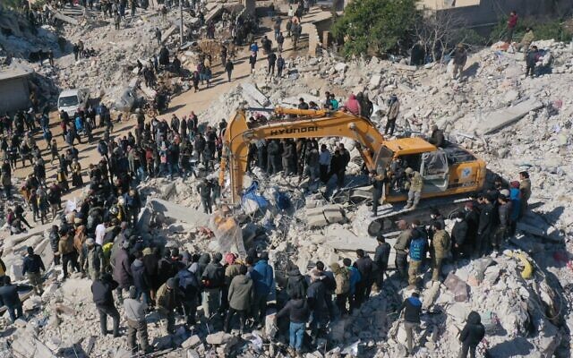 Une photo aérienne montrant des sauveteurs à la recherche de survivants au milieu des décombres d'un bâtiment effondré dans la ville de Harim, dans la province syrienne d'Idlib, au nord-ouest de la Syrie, à la frontière avec la Turquie, le 8 février 2023, deux jours après un tremblement de terre meurtrier qui a frappé la Turquie et Syrie. (Crédit : Omar HAJ KADOUR / AFP)