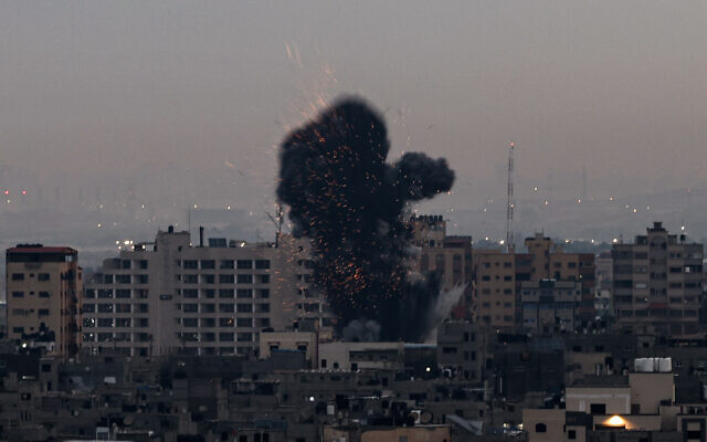 De la fumée s'élève au-dessus d'un immeuble de la bande de Gaza lors d'une frappe aérienne sur l'enclave palestinienne, le 23 février 2023. (Crédit :  MOHAMMED ABED / AFP)