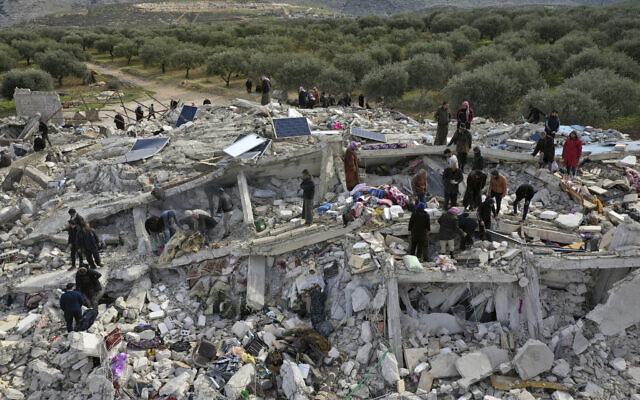 Des agents de la défense civile et des habitants cherchent dans les décombres de bâtiments effondrés dans la ville de Harem, près de la frontière turque, dans la province d'Idlib, en Syrie, le 6 février 2023 (Crédit : AP Photo/Ghaith Alsayed).