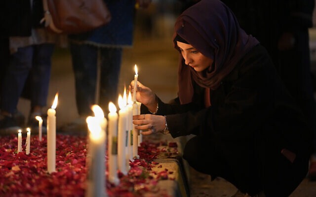 Une femme allume des bougies lors d'une veillée aux chandelles pour les victimes du tremblement de terre en Syrie et en Turquie, à Islamabad, au Pakistan, lundi 6 février 2023. (Crédit : AP Photo/Anjum Naveed)