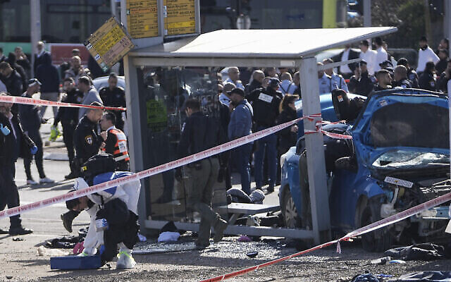 Une équipe médico-légale de la police israélienne travaillant sur les lieux d’un attentat à la voiture-bélier, à un arrêt de bus à Ramot, à Jérusalem, le 10 février 2023. (Crédit : AP Photo/Mahmoud Illean)