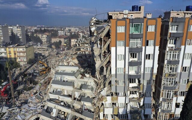 Des grues enlèvant des débris à côté de bâtiments détruits à Antioche, dans le sud-est de la Turquie, le 10 février 2023. (Crédit : AP Photo/Hussein Malla)