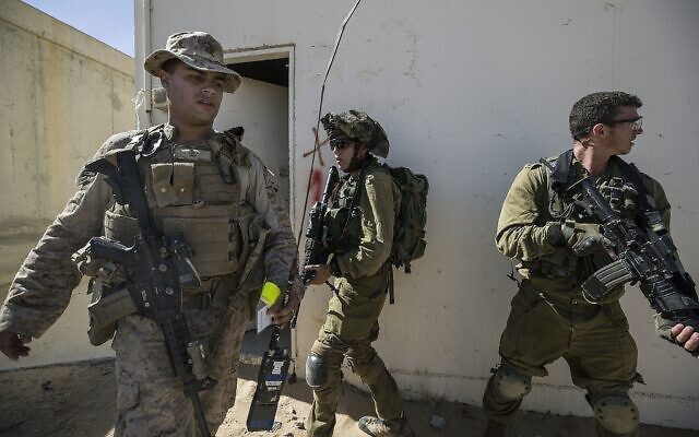 Des Marines américains et un soldat israélien participant à un exercice conjoint de guerre urbaine sur la base de Mala, au sud d'Israël, le 12 mars 2018. (Crédit : AP Photo/Tsafrir Abayov)