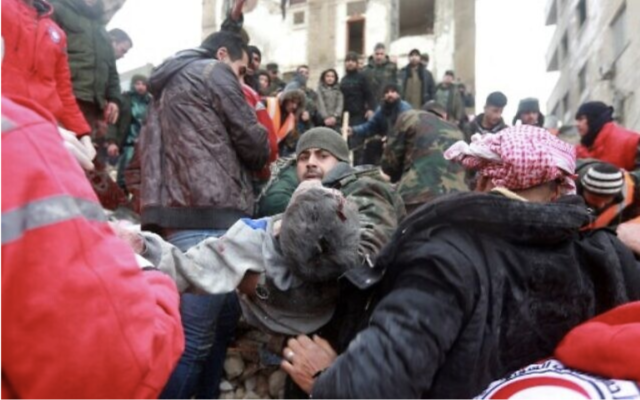 Des équipes de secours syriennes transportant un blessé retiré des décombres après un tremblement de terre dans la ville de Hama, au centre de la Syrie, contrôlée par le gouvernement, le 6 février 2023. (Crédit : Louai Beshara/AFP)