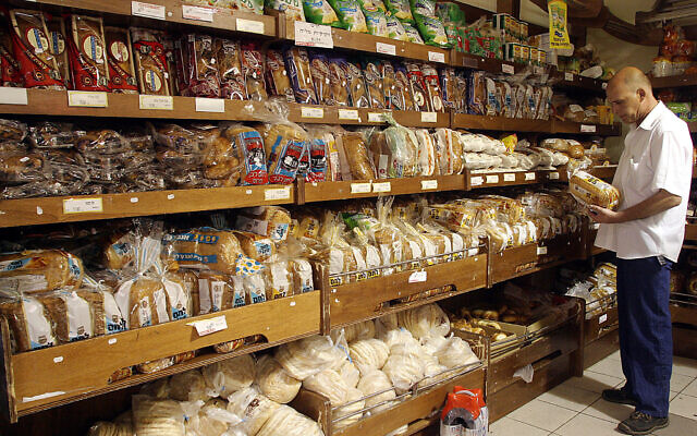 Illustration : Un homme achetant du pain dans un supermarché de Jérusalem. (Crédit : Orel Cohen/Flash90)