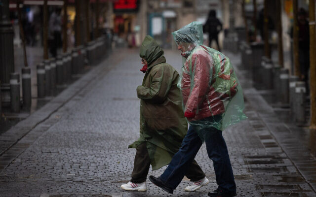Des personnes marchent sous la pluie dans le centre-ville de Jérusalem, le 1er février 2023. (Crédit : Yonatan Sindel/Flash90)