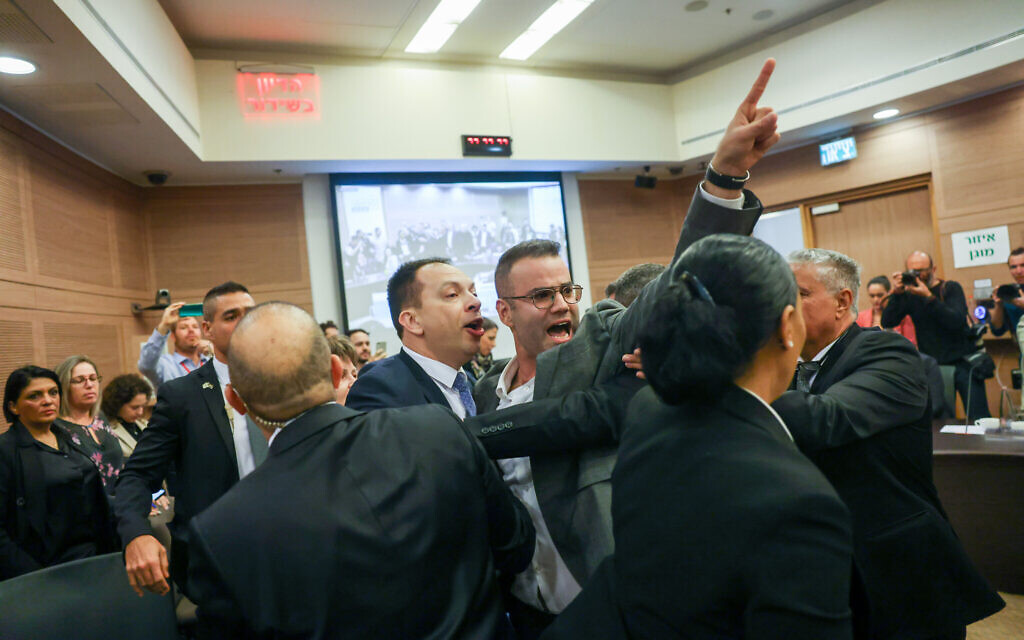 Des législateurs de l'opposition sont expulsés de la réunion de la commission de la Constitution, du droit et de la justice de la Knesset, le 13 février 2023 (Crédit : Yonatan Sindel/Flash90).
