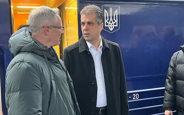 Le ministre des Affaires étrangères Eli Cohen, à droite, s'entretenant avec l'ambassadeur d'Israël en Ukraine, Michael Brodsky, après être descendu du train à Kiev, le 16 février 2023. (Crédit : Lazar Berman/Times of Israel)