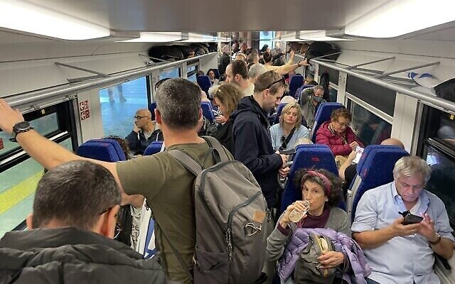 Des Israéliens ont pris place à bord d'un train reliant Tel Aviv à Jérusalem pour participer à une manifestation de grande ampleur contre la réforme judiciaire, le 20 février 2023. (Crédit : Carrie Keller Lynn/Times of Israel)