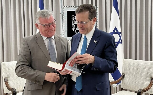 Le président du groupe britannique Labour Friends of Israel, le député vétéran Steve McCabe, à gauche, donne un livre signé par le chef de sa formation, Keir Starmer, au président Isaac Herzog, le 6 février 2023. (Crédit : Labour Friends of Israel)