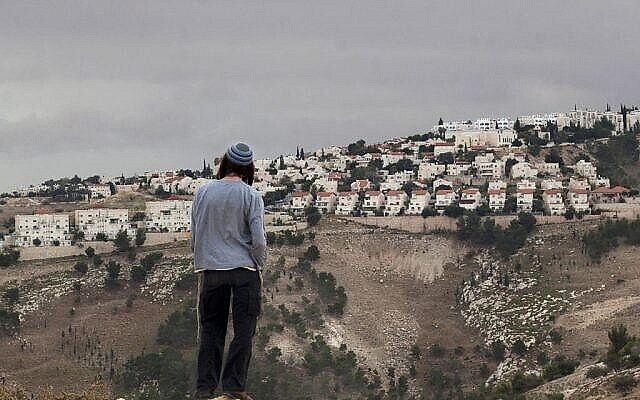 Archives : Un résident d'implantation israélien regarde l'implantation Maale Adumim, en Cisjordanie, depuis la zone E1, en périphérie est de Jérusalem. (Crédit : AP/Sebastian Scheiner)