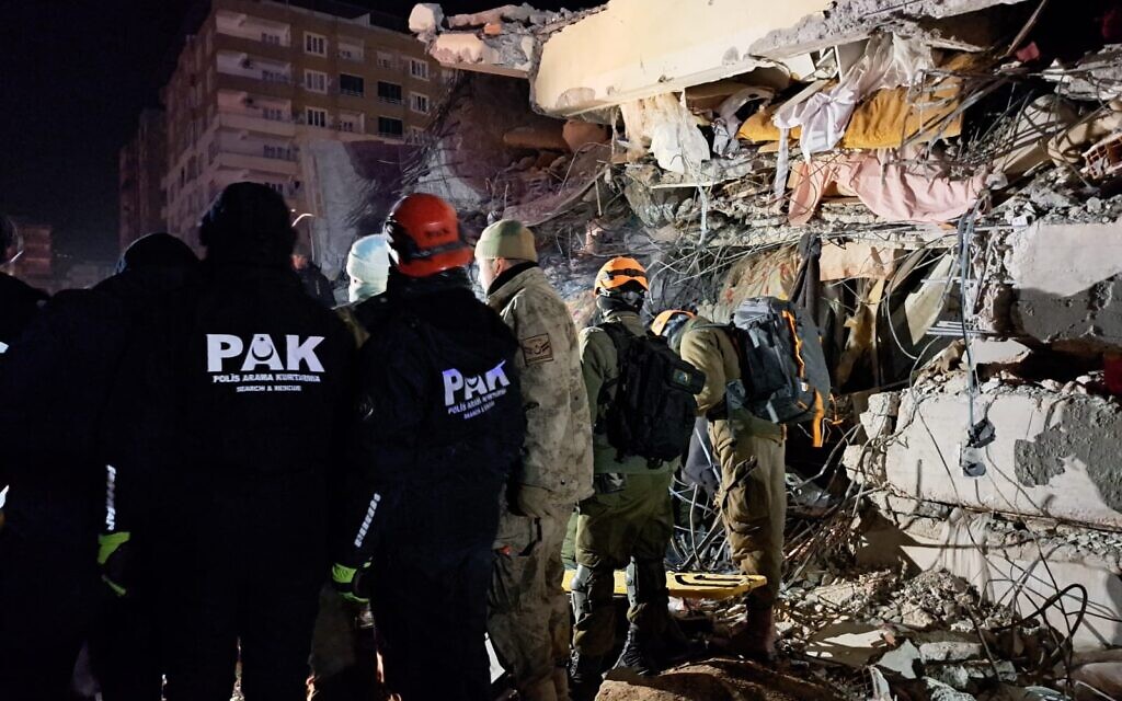 Les équipes de secours locales et israéliennes travaillent dans les décombres d'un immeuble à Marash, en Turquie, le 8 février 2023. (Crédit : Judah Ari Gross/Times of Israel)