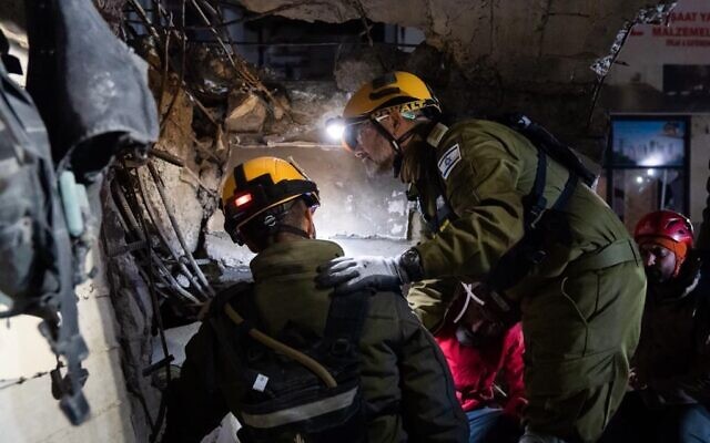 Des secouristes israéliens sauvant un garçon de 9 ans de sous les décombres à Kahramanmaraş, en Turquie, le 10 février 2023. (Crédit : Armée israélienne)
