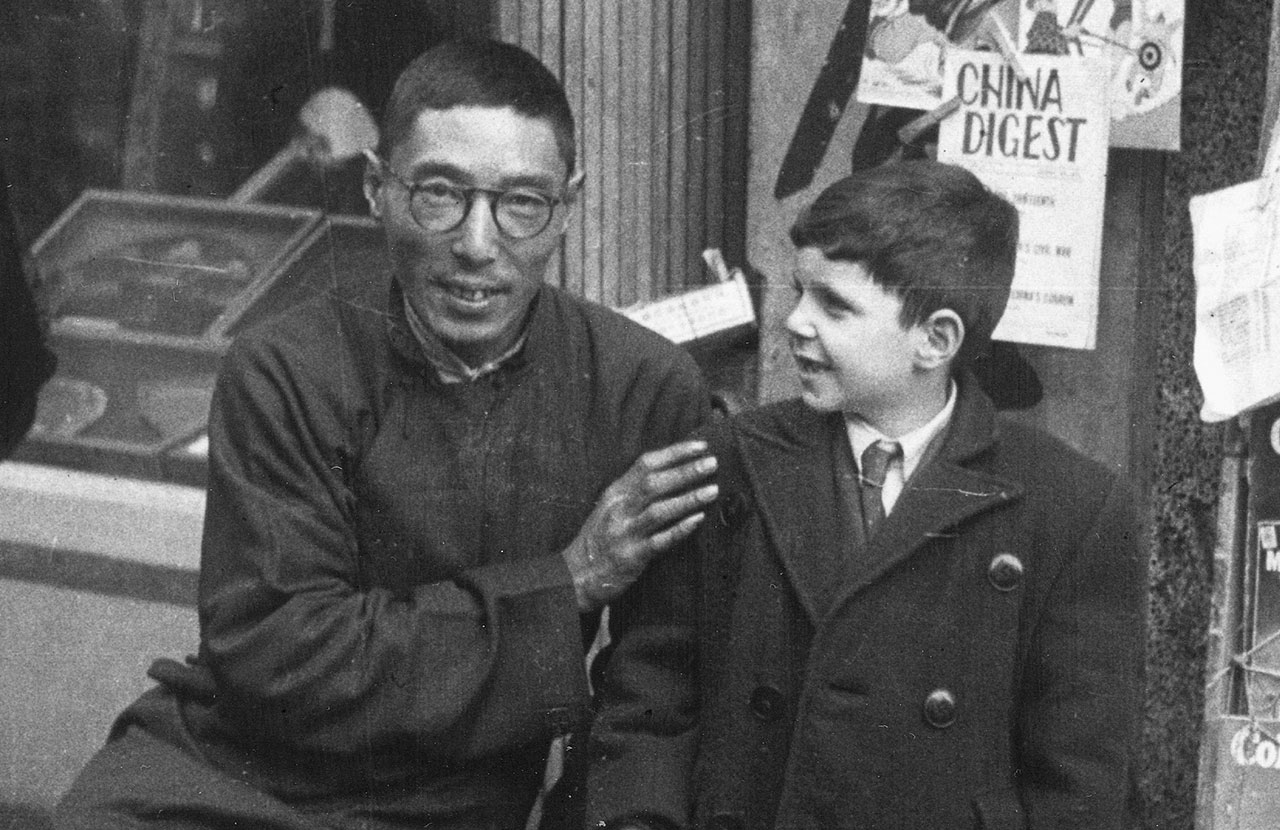  Un vendeur de journaux de Shanghai avec un jeune réfugié juif pendant la Seconde Guerre mondiale. (Crédit : Above the Drowning Sea/ Time & Rhythm Cinema)