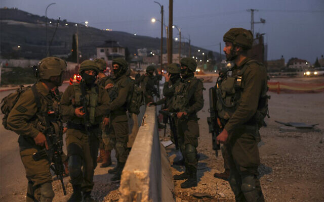 Des soldats de Tsahal patrouillant sur la route principale de Huwara, en Cisjordanie, le 27 février 2023. (Crédit : Ronaldo Schemidt/AFP)