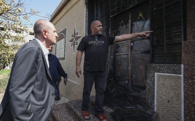 Le représentant spécial aux Affaires palestiniennes américain Hady Amr, à gauche,, parle aux résidents en inspectant les dégâts commis par des résidents d'implantation à Huwara, le 28 février 2022. (Crédit : JAAFAR ASHTIYEH / AFP)