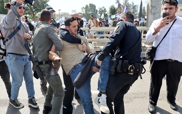 Des policiers israéliens retiennent un manifestant lors d'une manifestation contre la refonte controversée de la justice par le gouvernement, à Tel Aviv, le 1er mars 2023. (JACK GUEZ / AFP)