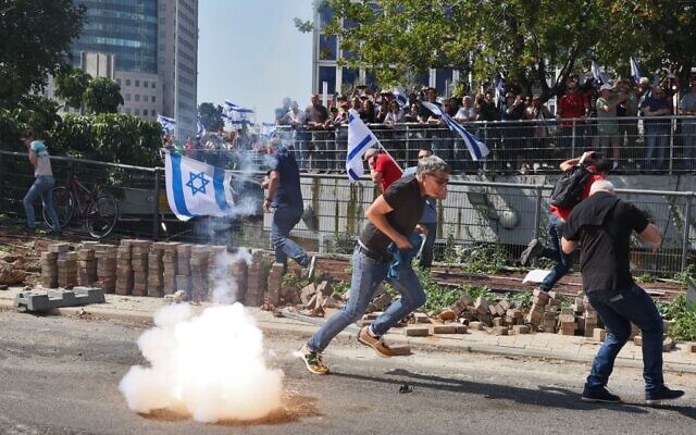 La police utilisant des grenades incapacitantes lors d'une manifestation contre le projet très controversé de réforme du système judiciaire du gouvernement, à Tel Aviv, le 1er mars 2023. (Crédit : Jack Guez/AFP)